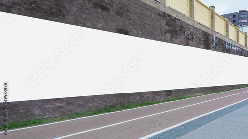 Long poster with mockup space mounted on stone wall at city street. Public advertisement and promotion concept.