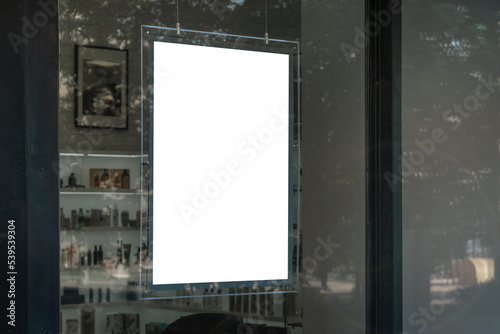 Photography Commercial blank white signboard hanging vertically behind window glass of bouti