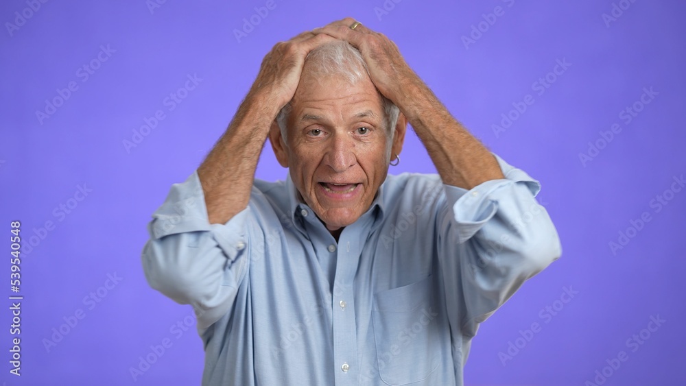 Sad upset worried disturb displeased shocked elderly gray-haired man 70s wears blue shirt sigh surprise put hands on face isolated on solid purple background studio portrait Sad upset worried disturb displeased shocked elderly gray-haired man 70s wears blue shirt sigh surprise put hands on face isolated on solid purple background studio portrait