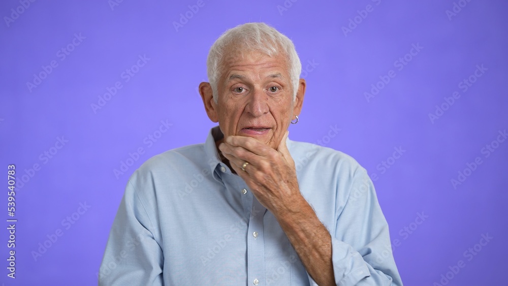 Sad upset worried disturb displeased shocked elderly gray-haired man 70s wears blue shirt sigh surprise put hands on face isolated on solid purple background studio portrait Sad upset worried disturb displeased shocked elderly gray-haired man 70s wears blue shirt sigh surprise put hands on face isolated on solid purple background studio portrait