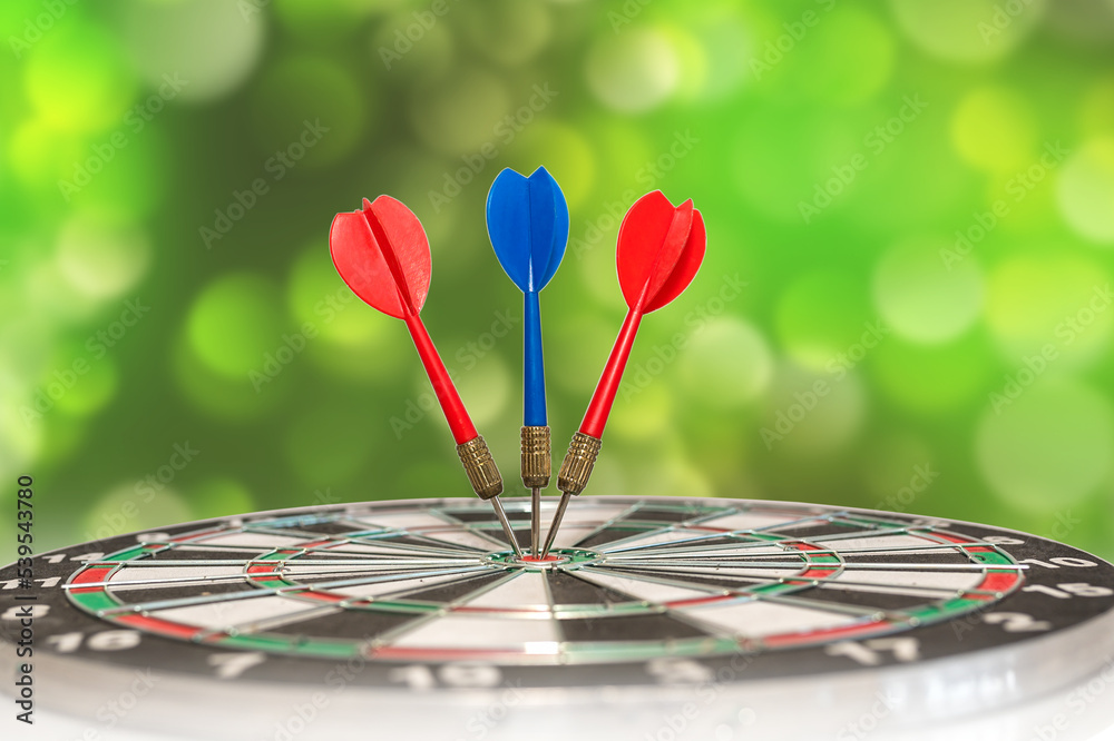 Fototapeta premium Playing darts with darts on a bokeh background. Competition and sport.