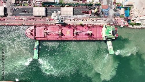 Tug boat drag pull cargo container ship from dry dock concept maintenance service working in the sea. Insurance and Maintenance Cargo Ship concept. Freight Forwarding Service maintenance Insurance photo
