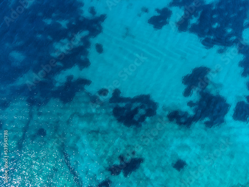 Aerial drone view of transparent sea water at summer. Beautiful tropical sea surface, view from above. Sea waves.
