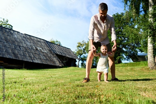 Dad teaching his daughter to walk photo