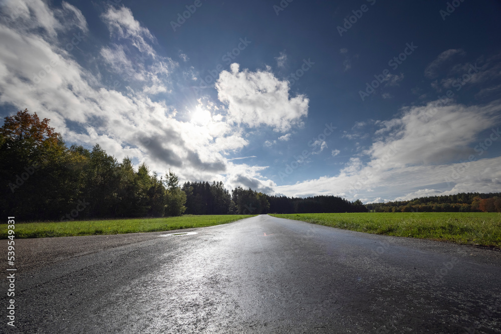 asphalt road in the countryside with sky and amazing clouds