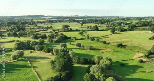 Aerial view flying backwards of valley in hilly countryside with small river Geul and grassland, Geuldal, Mechelen, Zuid Limburg, Netherlands photo
