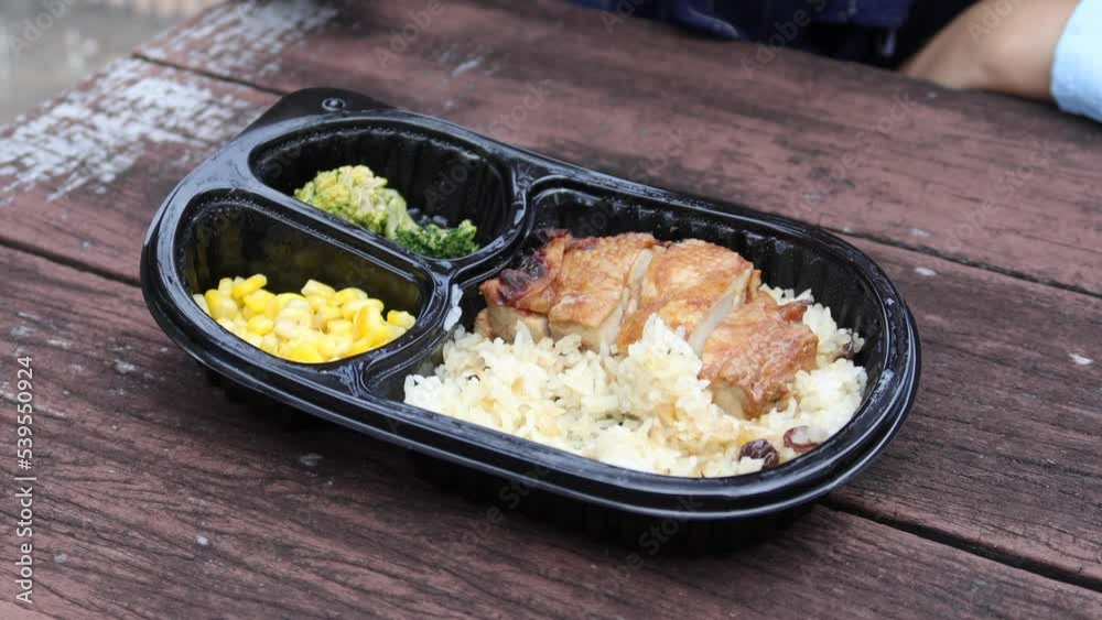 curry chicken and rice in a take away plastic packet on table curry chicken and rice in a take away plastic packet on table