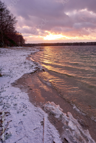 Fototapeta Naklejka Na Ścianę i Meble -  Pink sunset over frozen lake. Sunset reflection in frozen lake.