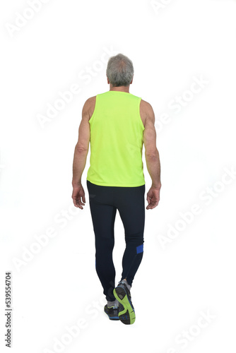 back view of a senior man with sportswear walking on whitebackground © curto