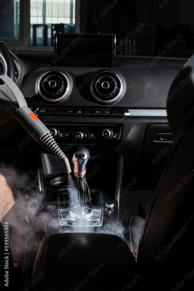 Steam cleaning of gearbox and dashboard in car. Vaping steam. Cleaning