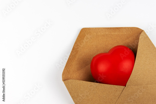 Close up of heart shape in a brown envelope on white background