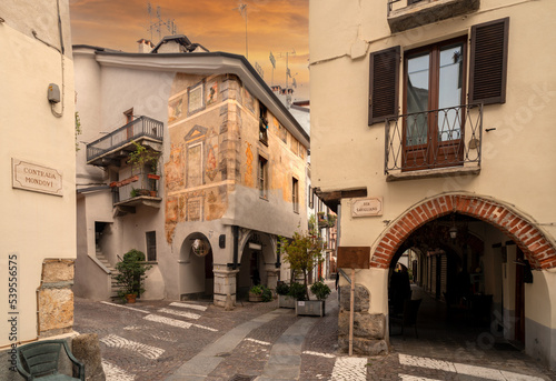Cuneo, Piedmont, Italy - October 14, 2022: Contrada Mondovì, ancient street in the historic center with frescoed medieval buildings at sunset photo