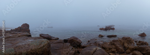 Fototapeta Naklejka Na Ścianę i Meble -  Panorama of rock formation at the sea in the fog on a hazy mystic autumn morning in Sillon de Talbert area, Brittany, France