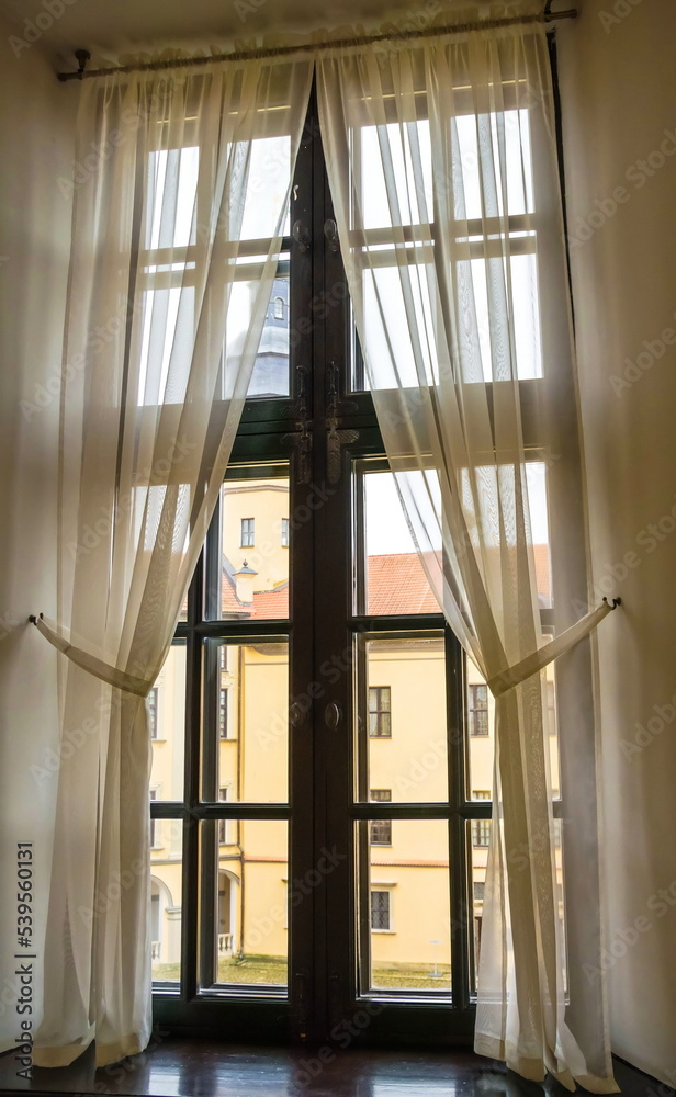 Obraz premium The window of an old house with light light curtains