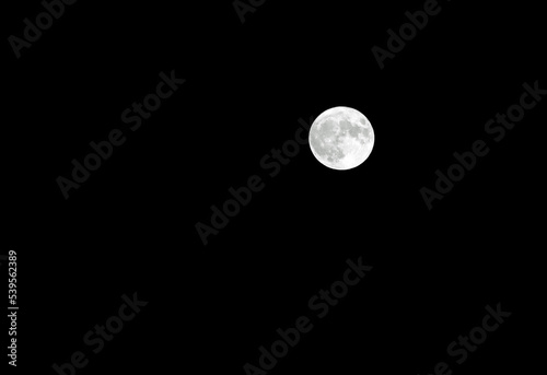 shining full moon and craters can be seen in the sky