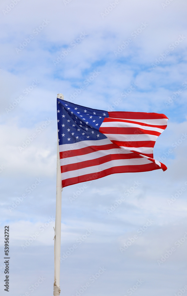 american flag with stars and red and white stripes on blue sky