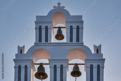 Fira.Yellow - Colorful Bell Tower of the Agios Theodoros Church - Fira Village in Santorini Island, Greece - Sunset photo