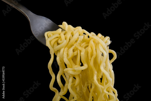 Pasta on a fork isolated on a black background.