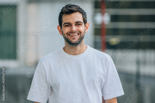 Schilderij op canvas portrait of young man on the street smiling