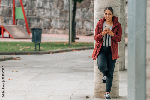 girl on the street with mobile phone full body