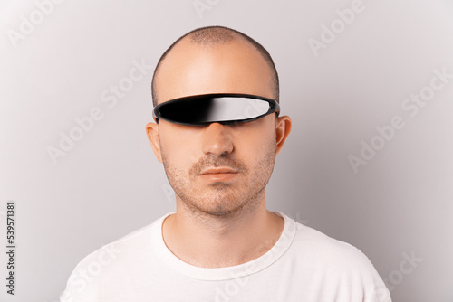 Photos Close up shot of a serious young bald man wearing one eye cyclops glasses