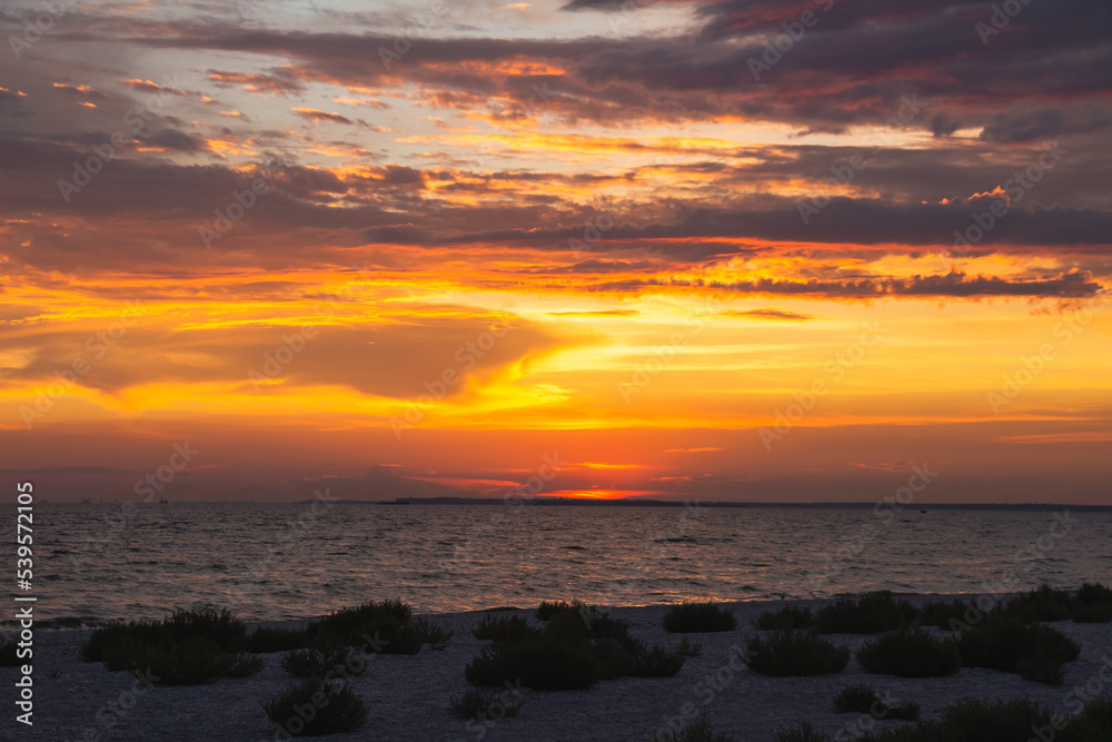 Amazing Black sea. Clouds and sand landscape background. Drama yellow sky and red sun. Golden blue hour at the ocean romantic evening. Tropical island summer paradise. Wild rest in camp. Amazing Black sea. Clouds and sand landscape background. Drama yellow sky and red sun. Golden blue hour at the ocean romantic evening. Tropical island summer paradise. Wild rest in camp.