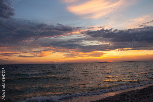 Amazing Black sea Kinburn spitz evening and surf line. Clouds landscape background. Drama yellow sky and sun. Golden blue hour at ocean romantic evening. Tropical summer paradise. Wild rest in camp.