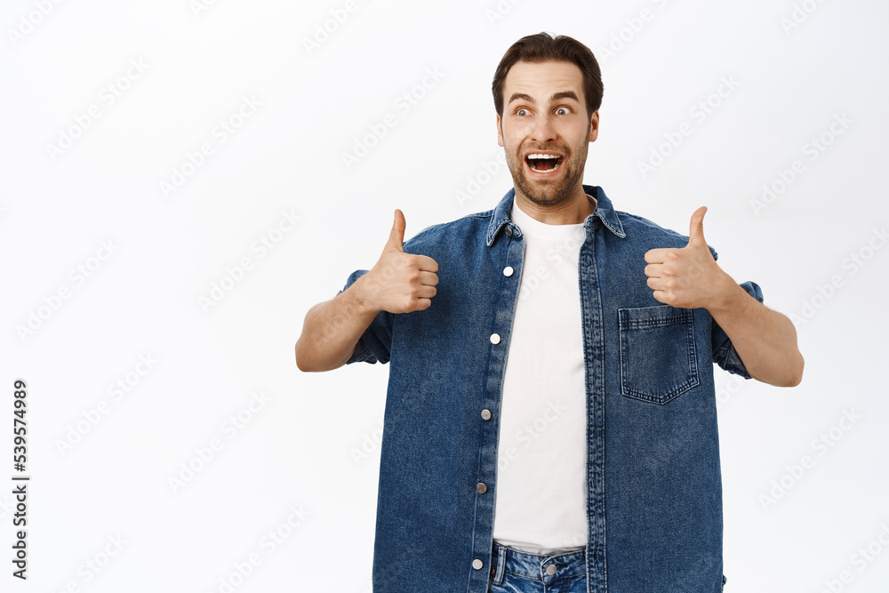 Handsome smiling bearded man, shows thumbs up, approve smth, recommending product, praise or compliment you, standing over white background Handsome smiling bearded man, shows thumbs up, approve smth, recommending product, praise or compliment you, standing over white background