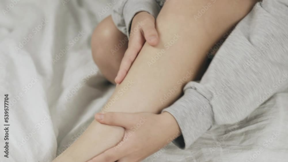 A teenager girl massages her leg with her hands. Close up. A teenager girl massages her leg with her hands. Close up.