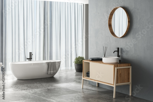 Modern bathroom interior with blue background  concrete flooring  white bathtub  shower and sink  side view. Minimalist bathroom with modern furniture. 3D rendering