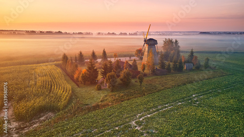 Obraz na płótnie Traditional Wooden Windmill Morning Landscape. Rural colorful Sunrise, Foggy green fields. Dudutki village w salonie