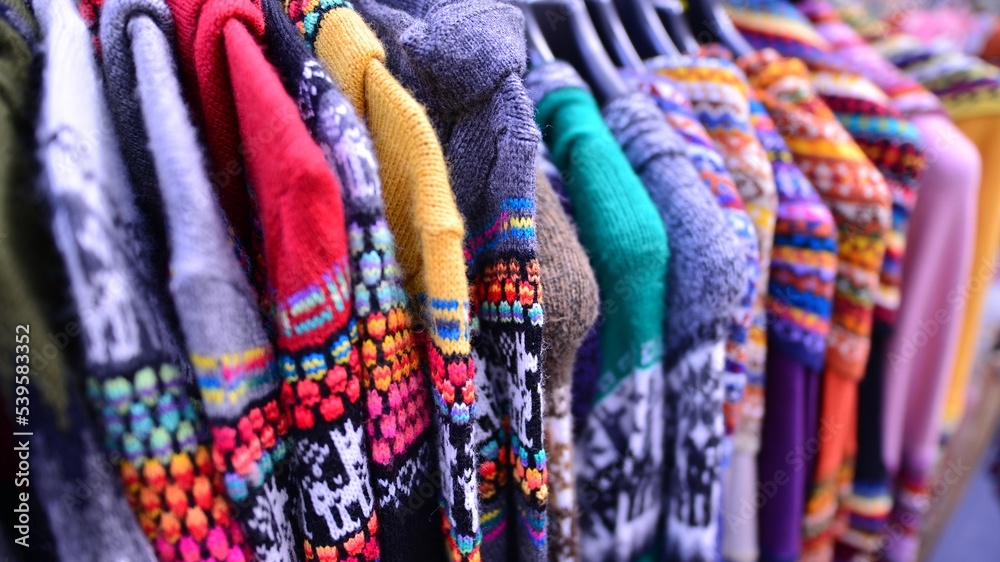 Made in Peru handicraft woolen, jackets, sweaters and vests made from alpaca with traditional design at market.