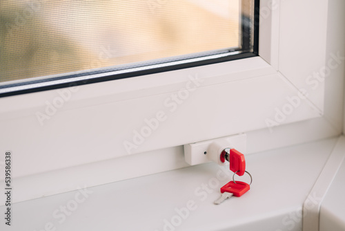 Close-up of child safety lock on a window frame an apartment on a high floor. Security lock for windows ensures the safety of your children and prevents accidents