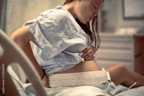 A woman having painful contractions before birth, waiting in the hospital delivery room. Women in labor. photo