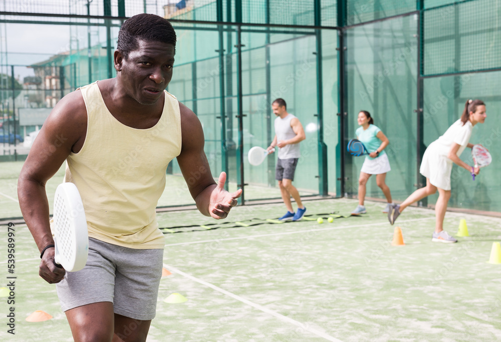 Portrait of young adult man paddle tennis player preparing to game at court during group training