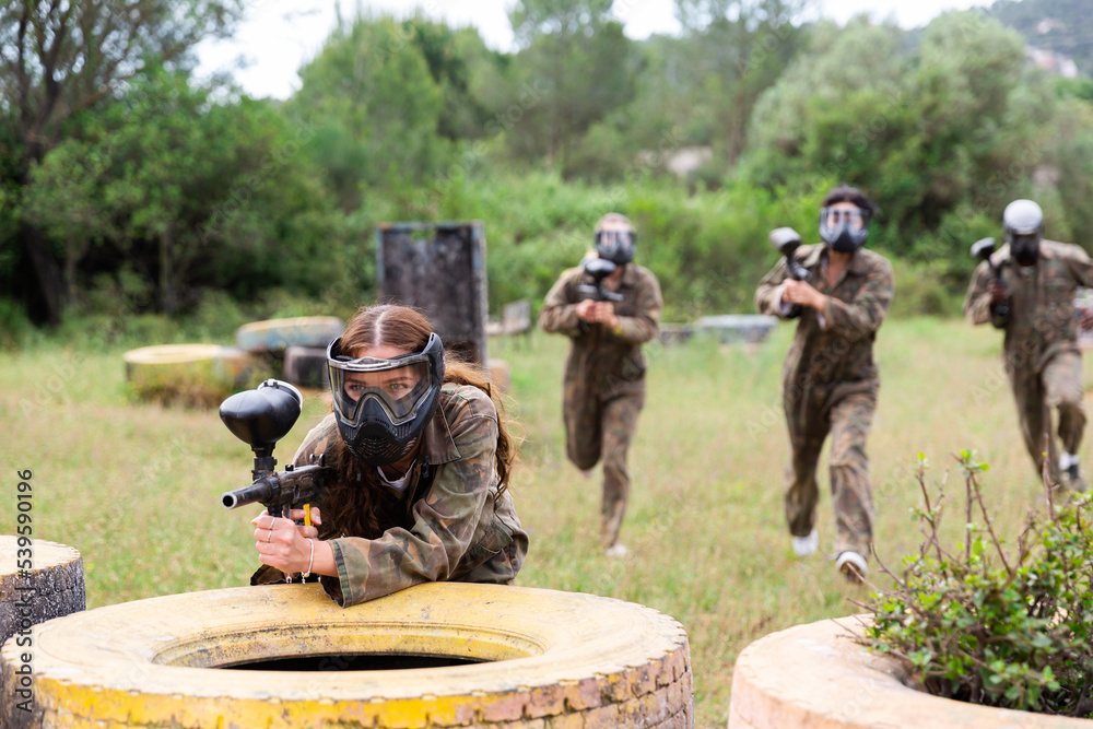 Fototapeta premium Team of friends paintball players playing together in battle in forest