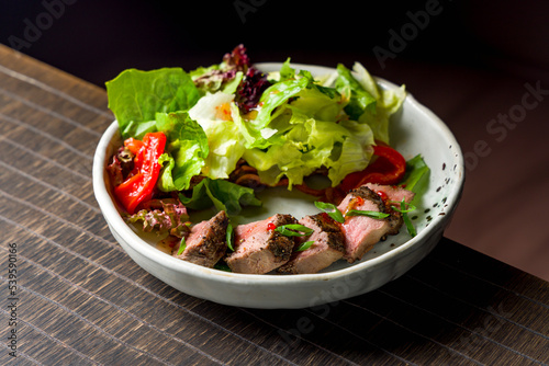Salad with roast beef and greens with green onion and sauce
