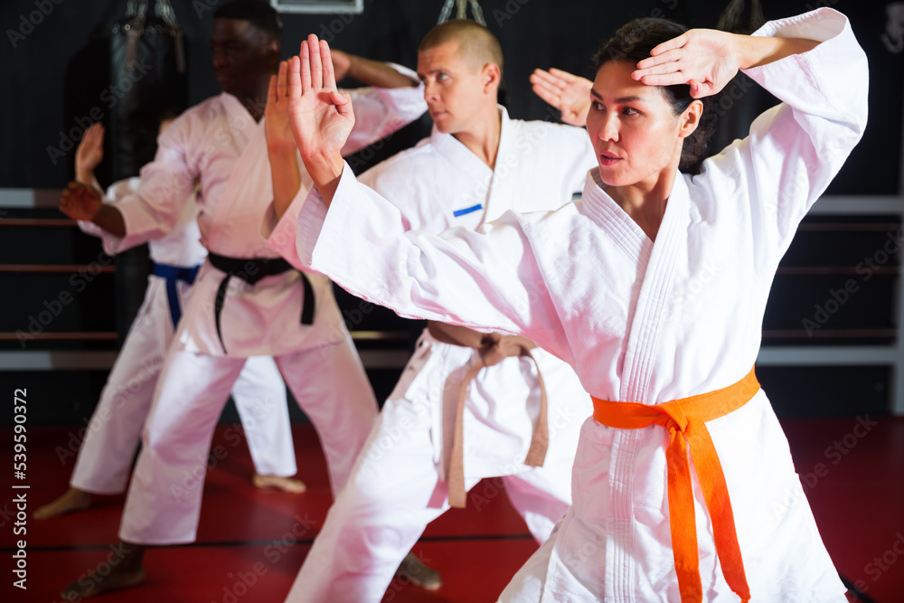 Obraz premium Karate or taekwondo training - athletes in kimono stand in a fighting stance