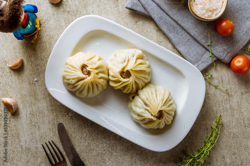 Mongolian buuz on white plate on grey table top view