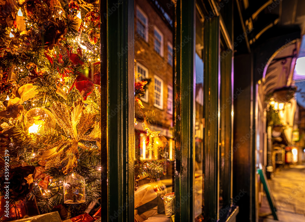 A Chirstmas night view of Shambles, a historic street in York featuring preserved medieval timber-framed buildings with jettied floors