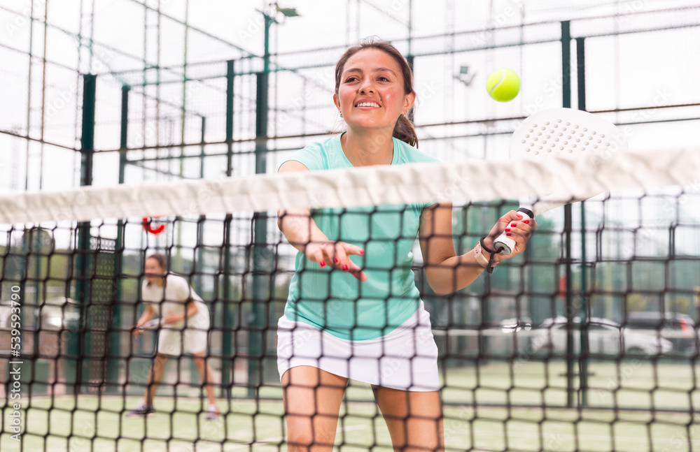 Portrait of emotional woman paddle tennis player during friendly doubles couple match at court