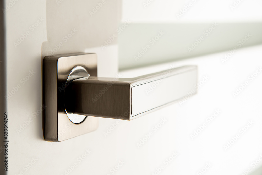 Obraz premium modern metal door handle on white door