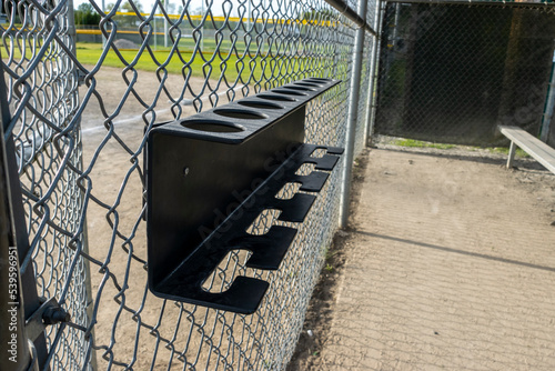 Close up view of a baseball bat holder inside a dugout at a sports field park photo