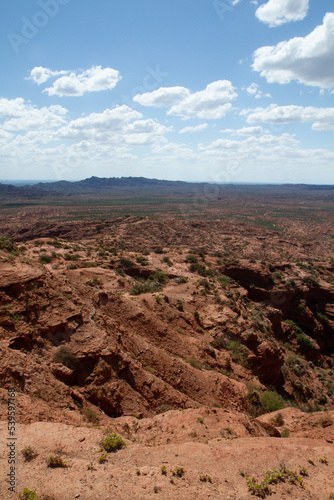 The steep canyon. Panorama view of the red desert, cliffs, orange sandstone formations and rocky mountains in the horizon in Sierra de las Quijadas national park in San Luis, Argentina.