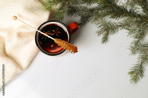 Stick with sugar crystals and cup of drink on white table, flat lay. Space for text
