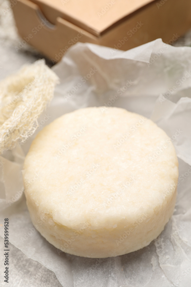 Solid shampoo bar on light grey table, closeup Solid shampoo bar on light grey table, closeup