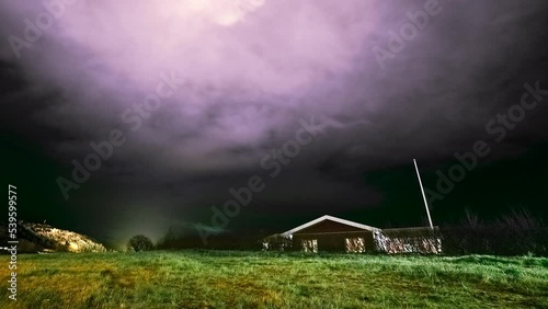 Night stormy clouds motion time lapse - aurora borealis and lonely rural house whith stormy skyes Nothern lights nature background photo