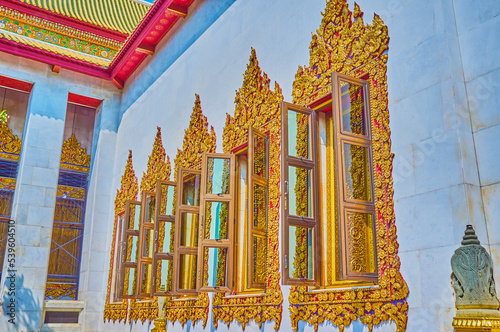 The carved golden window frames of Ubosot of Wat Bowonniwet Vihara in Bangkok, Thailand photo