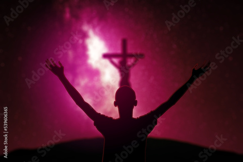 Man praying to God near crucifixes at night