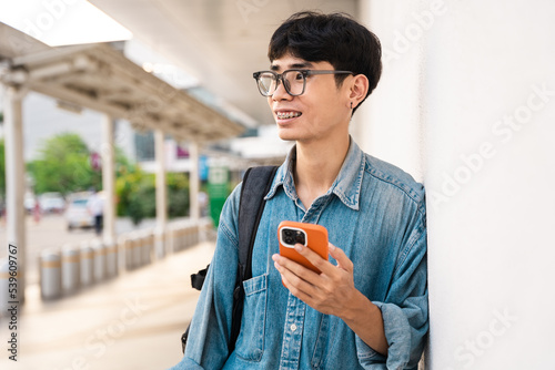 A picture of an Asian male student using a mobile phone